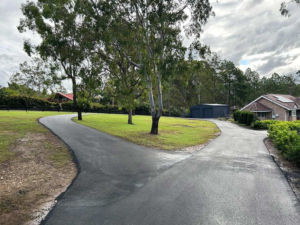 A Curvy Driveway Leading to a House With Trees on Both Sides — North Coast Asphalts in Corindi Beach, NSW
