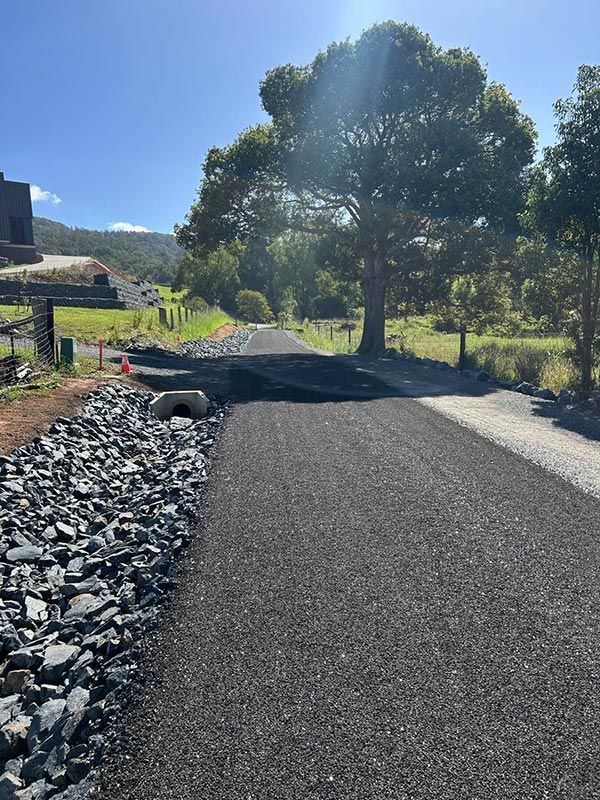 A Road With Rocks on the Side of It and a Tree in the Background — North Coast Asphalts in Yamba, NSW