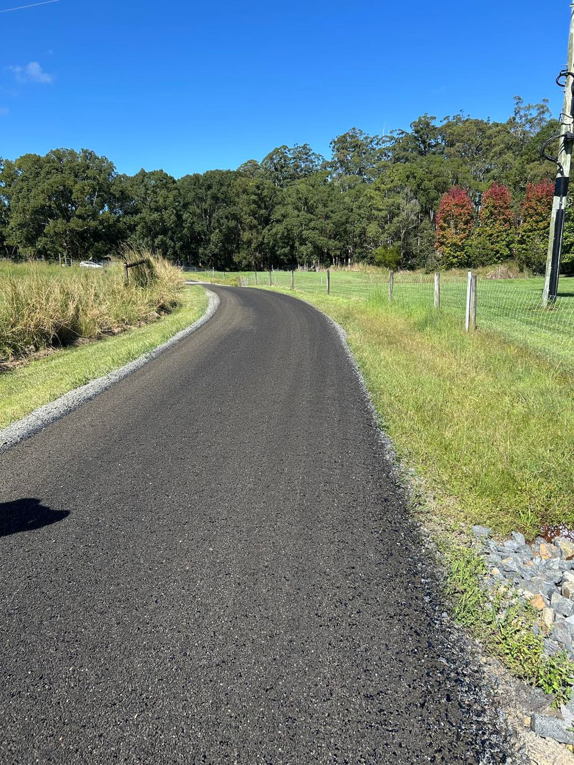 A Road That is Going Through a Grassy Field — North Coast Asphalts in Yamba, NSW