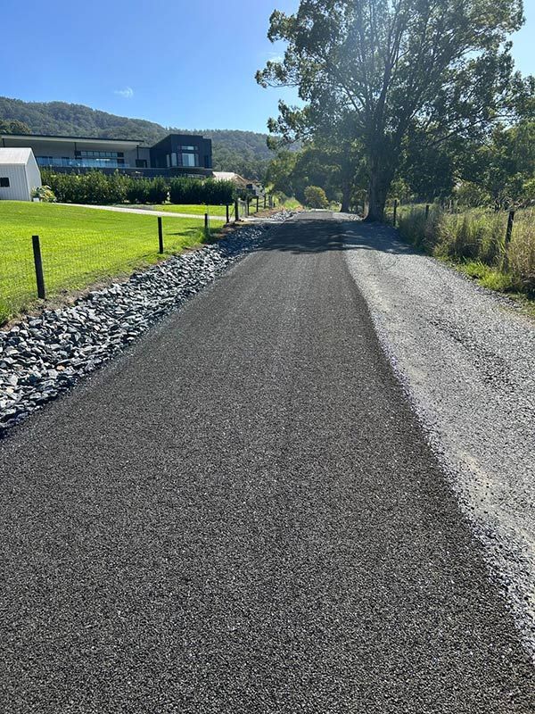 A dirt road with a house in the background — North Coast Asphalts in Yamba, NSW
