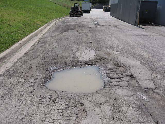 A Puddle of Water is in the Middle of a Road — North Coast Asphalts in Port Macquarie, NSW