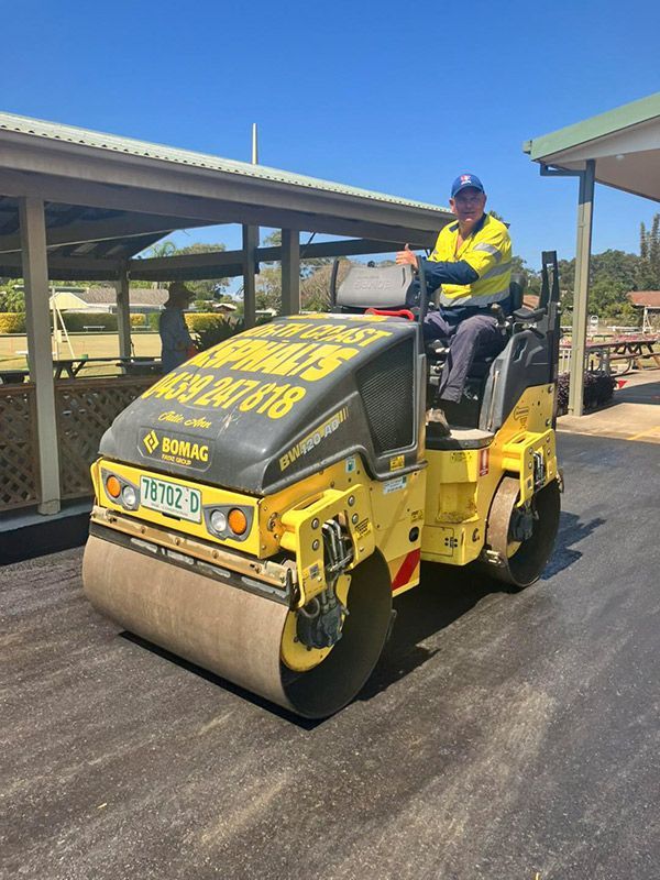 A Man is Driving a Yellow Roller on a Road — North Coast Asphalts in Corindi Beach, NSW