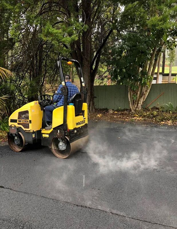 A Man is Driving a Yellow Roller on a Road — North Coast Asphalts in Corindi Beach, NSW