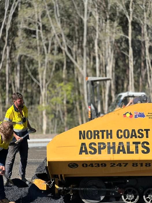 Road workers spreading asphalt beside a North Coast Asphalts machine.— North Coast Asphalts in Corindi Beach, NSW