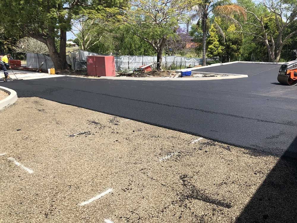 A Roller is Rolling Asphalt in a Parking Lot — North Coast Asphalts in Corindi Beach, NSW