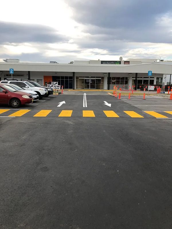 A Parking Lot With Cars Parked in Front of a Building — North Coast Asphalts in Corindi Beach, NSW