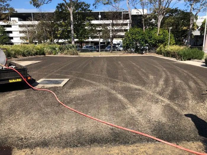 A Hose is Connected to a Trailer in a Parking Lot — North Coast Asphalts in Corindi Beach, NSW