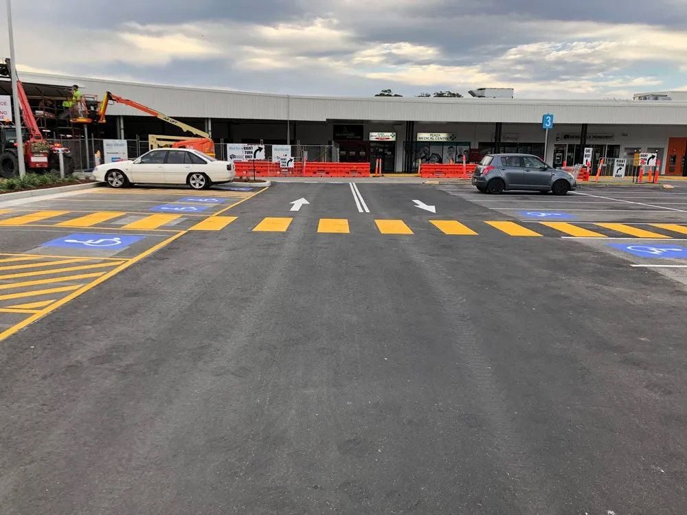A Parking Lot With Cars Parked in Front of a Building — North Coast Asphalts in Corindi Beach, NSW