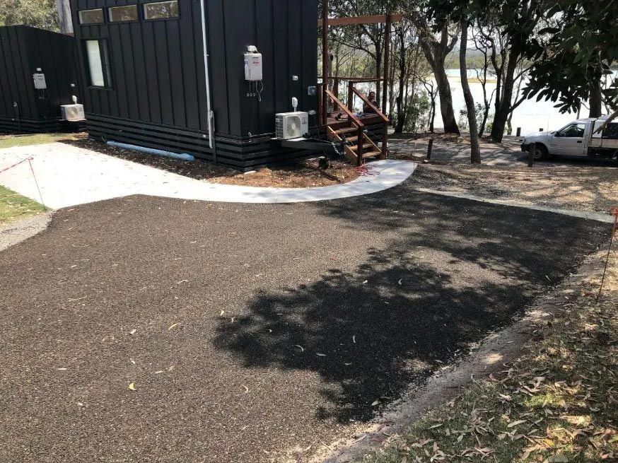 A Black House With a White Truck Parked in Front of It — North Coast Asphalts in Corindi Beach, NSW