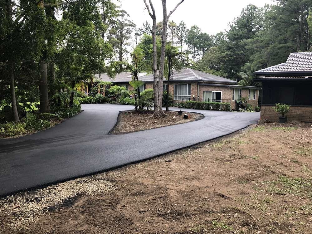 A Driveway Leading to a House Surrounded by Trees — North Coast Asphalts in Corindi Beach, NSW