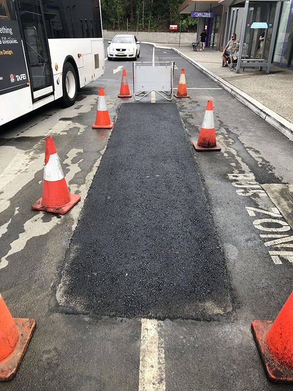 A Bus is Parked on the Side of the Road Next to a Bunch of Traffic Cones — North Coast Asphalts in Corindi Beach, NSW