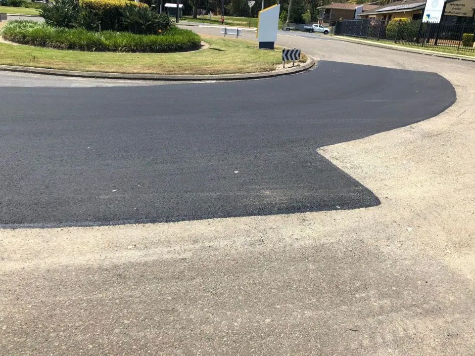 A Black Asphalt Road With a Roundabout in the Middle of It — North Coast Asphalts in Corindi Beach, NSW