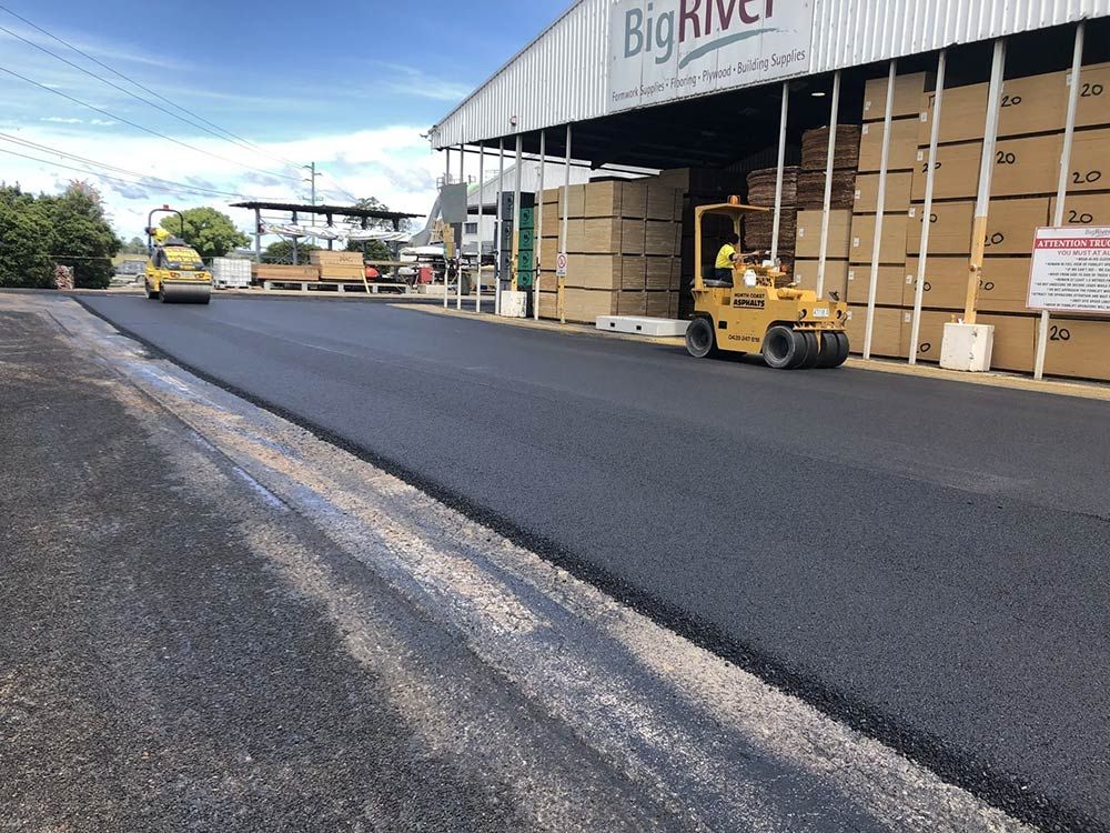 A Forklift is Driving Down a Road in Front of a Building — North Coast Asphalts in Corindi Beach, NSW