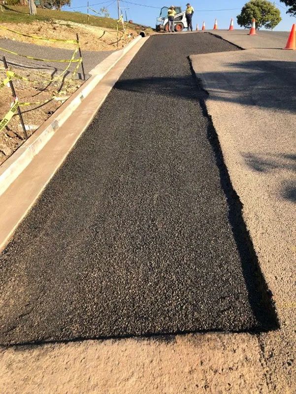 A Piece of Asphalt is Being Installed on the Side of a Road — North Coast Asphalts in Corindi Beach, NSW