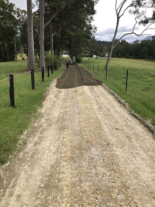 A Dirt Road Going Through a Grassy Field — North Coast Asphalts in Corindi Beach, NSW