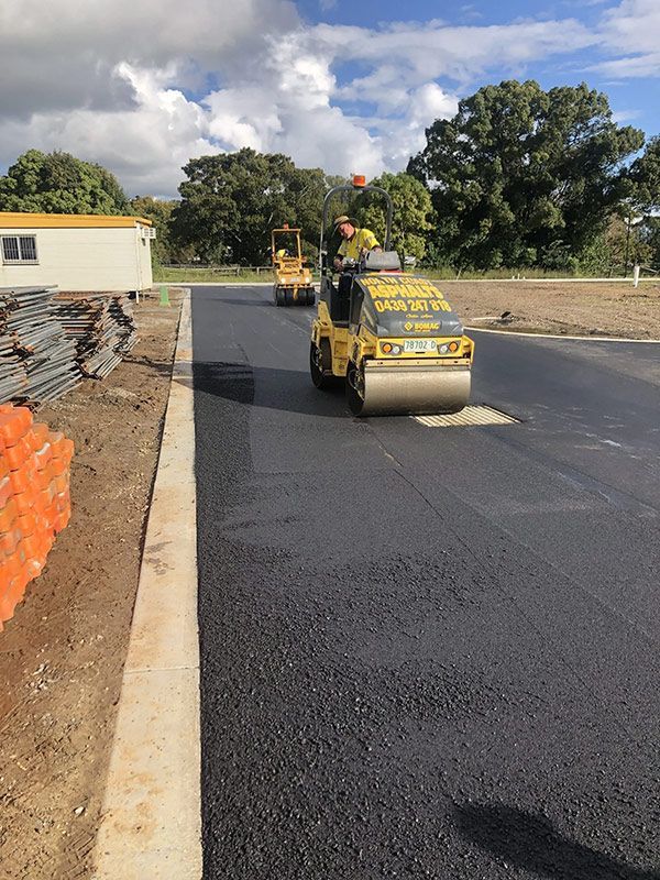 A Man is Driving a Yellow Roller on a Road — North Coast Asphalts in Corindi Beach, NSW