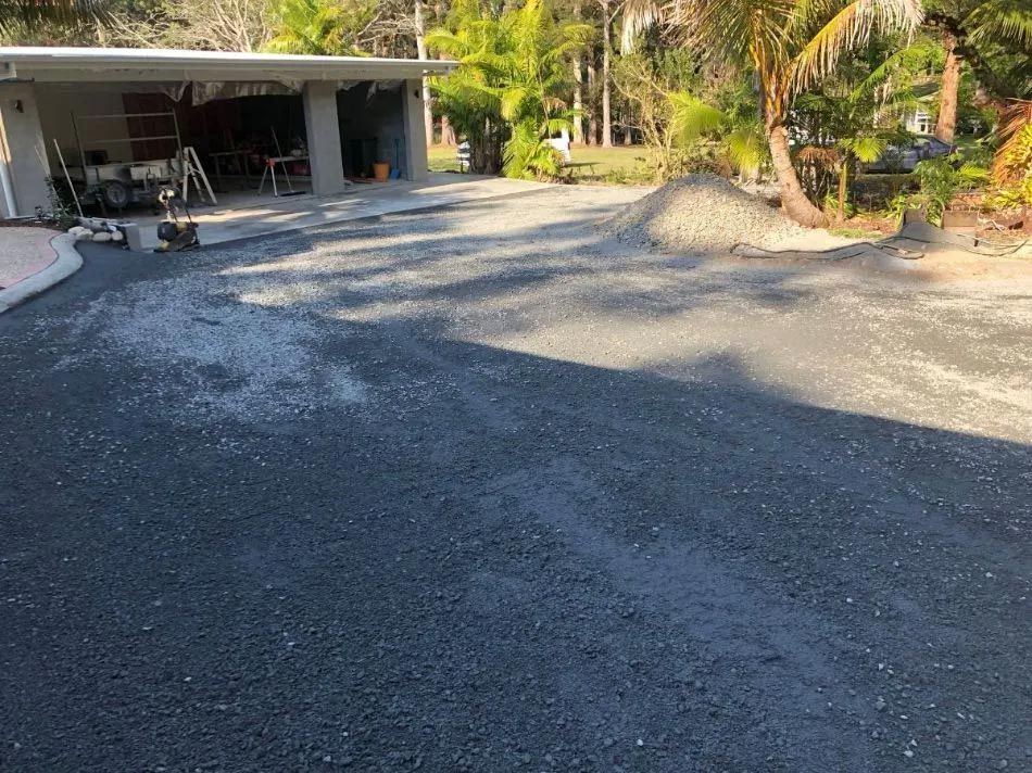 A Driveway Leading to a House With a Garage and Palm Trees — North Coast Asphalts in Corindi Beach, NSW