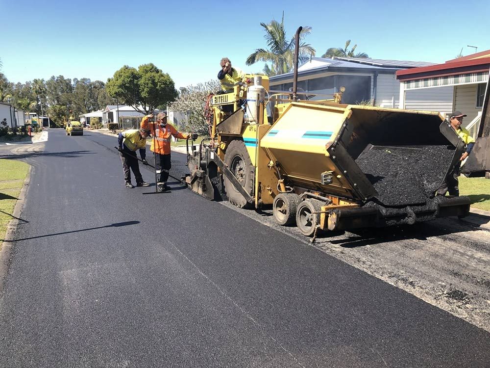 A Group of Construction Workers Are Working on a Road — North Coast Asphalts in Corindi Beach, NSW