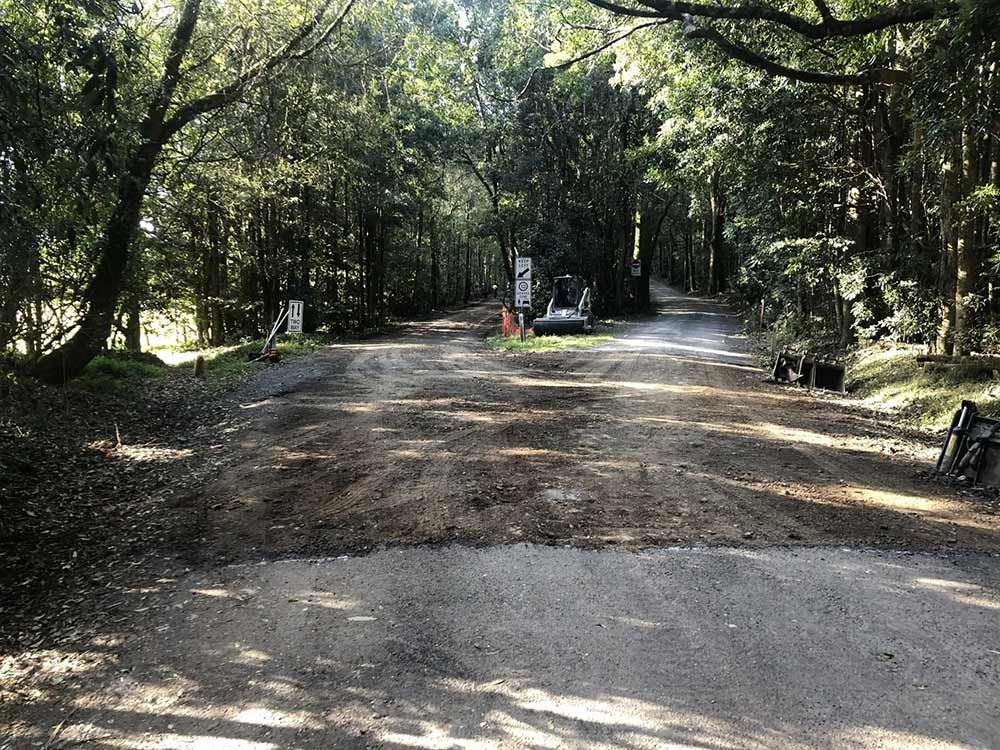 A Dirt Road Going Through a Forest With Trees on Both Sides — North Coast Asphalts in Corindi Beach, NSW
