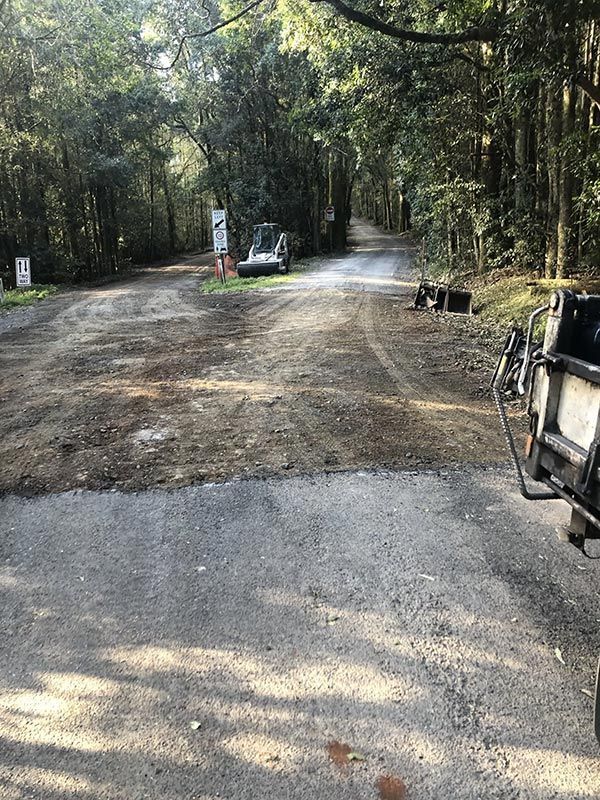 A Motorcycle is Parked on the Side of a Dirt Road in the Woods — North Coast Asphalts in Corindi Beach, NSW
