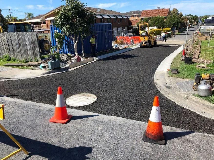 Two Orange and White Traffic Cones Are Sitting on the Side of a Road — North Coast Asphalts in Corindi Beach, NSW