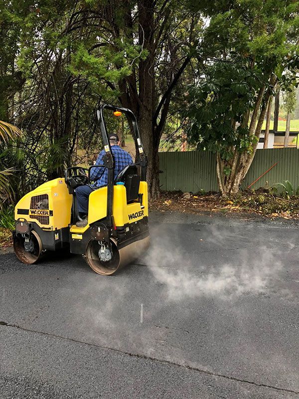 A Man is Driving a Yellow Roller on a Road — North Coast Asphalts in Corindi Beach, NSW