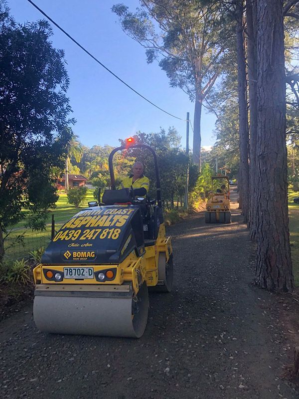A Yellow Asphalt Roller is Parked on the Side of a Road — North Coast Asphalts in Corindi Beach, NSW