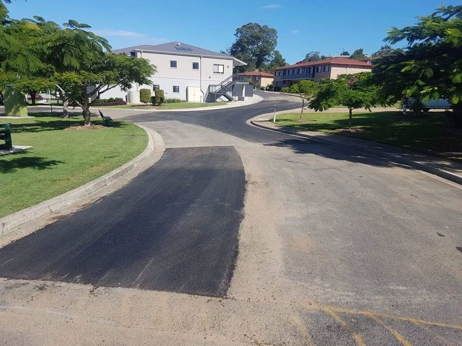 A Road With a Patch of Black Asphalt in the Middle of It — North Coast Asphalts in Corindi Beach, NSW
