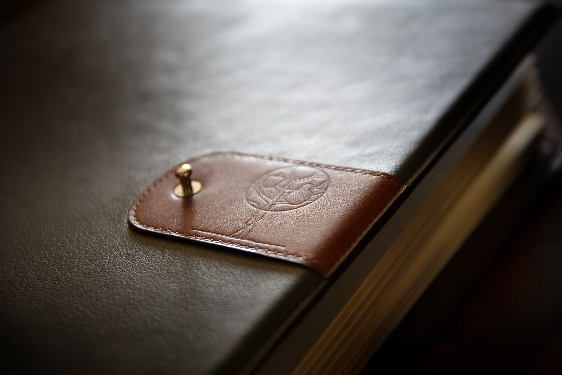 Logo Pom Poire gauffré sur pochette en cuir