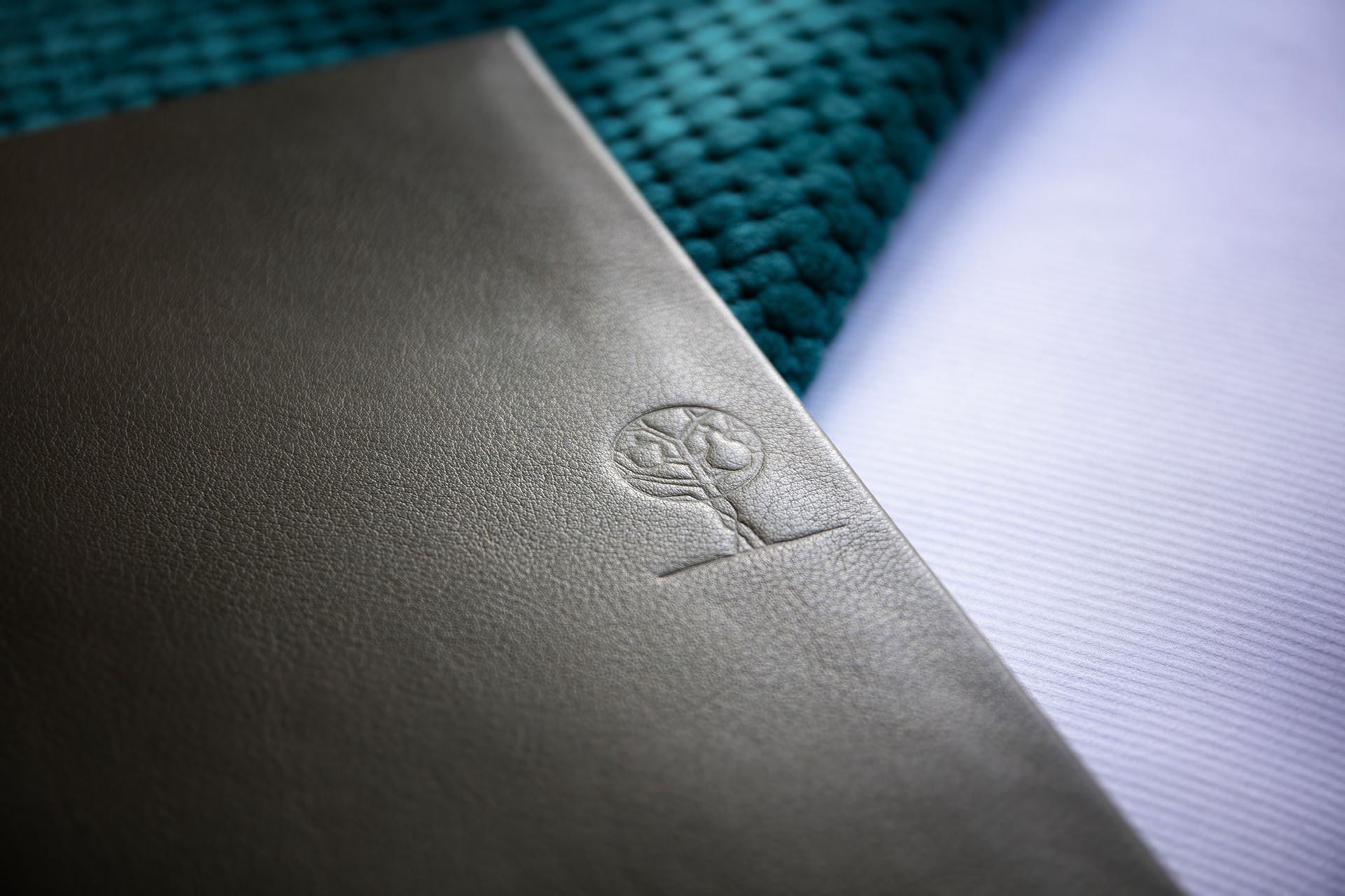 Logo Pom Poire gauffré sur pochette en cuir