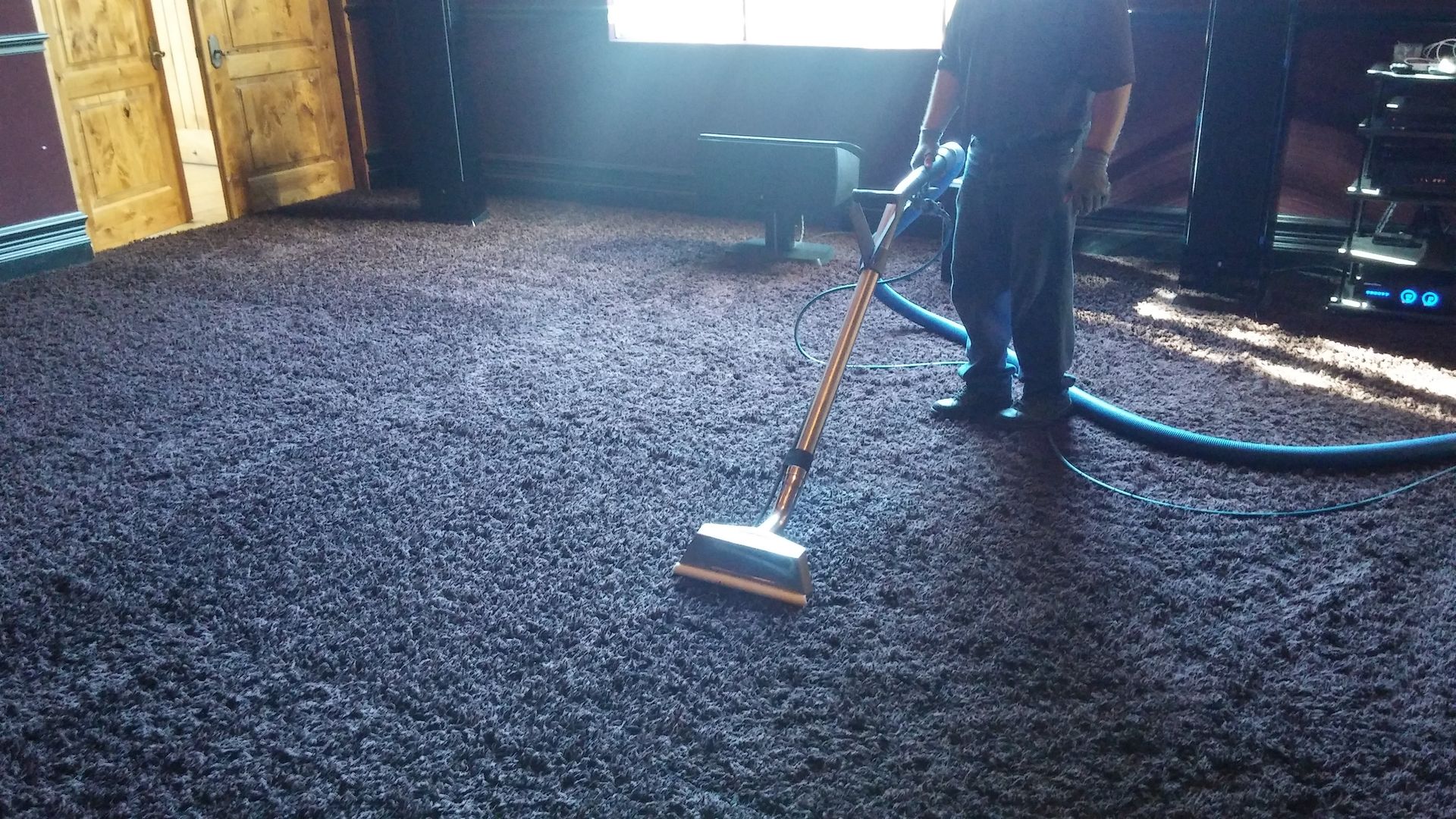 A person is using a vacuum cleaner on a carpeted floor