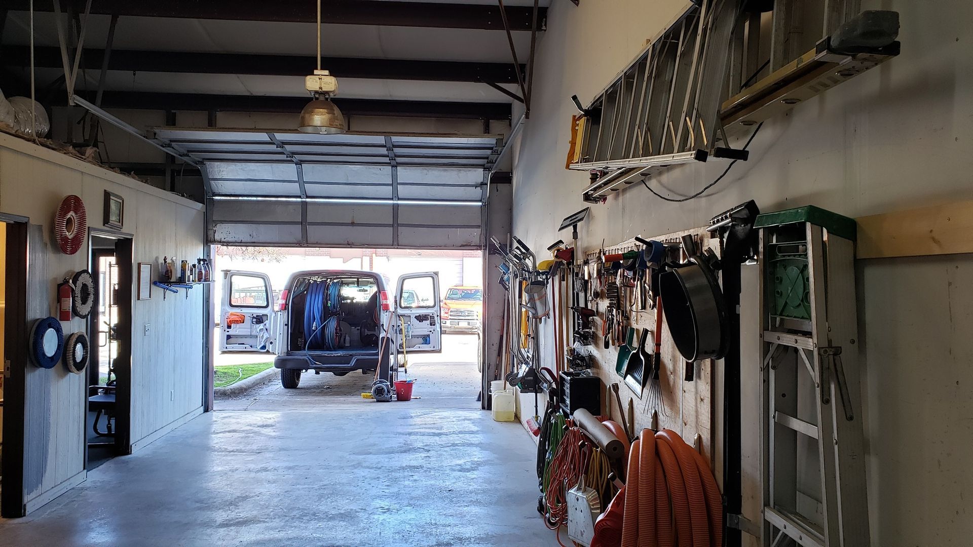 A car is parked in a garage with a garage door open.
