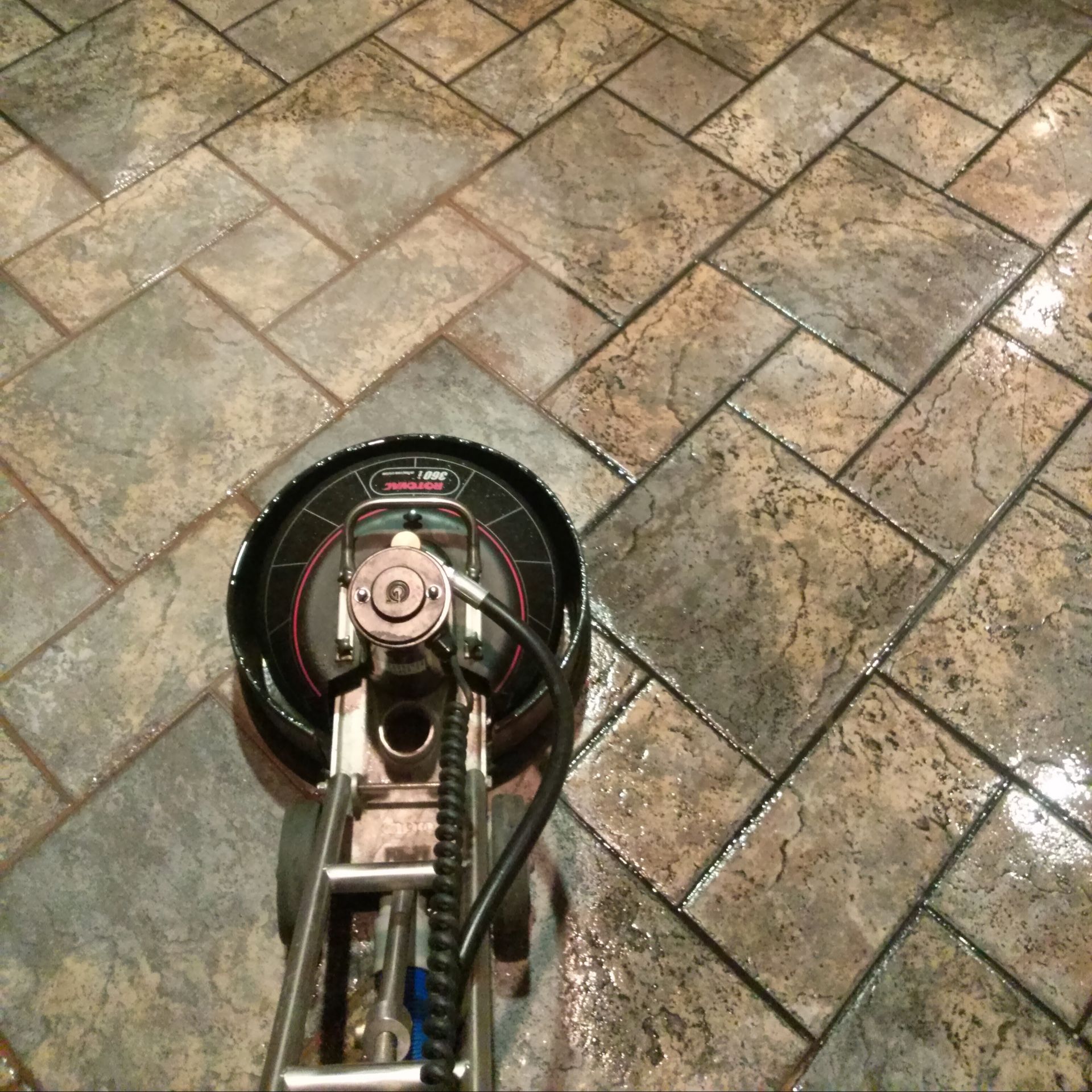 A tile floor is being cleaned with a machine