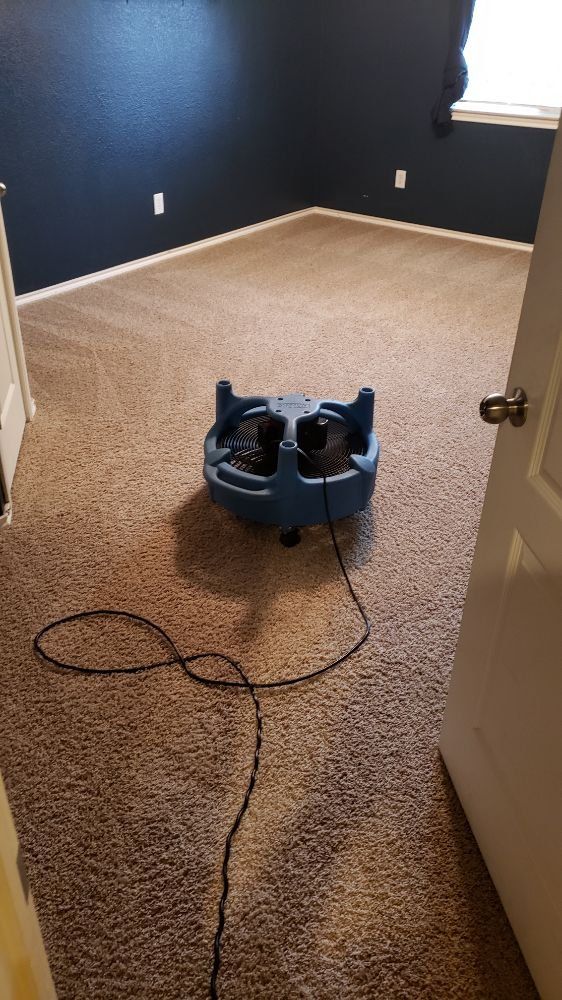 A vacuum cleaner is sitting on the floor of a room next to a door.