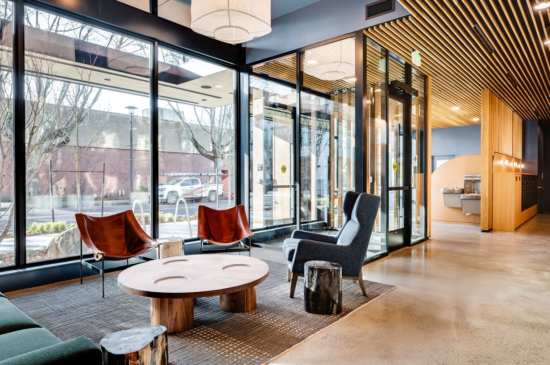 Modern lobby with seating, large windows, and natural wood accents.
