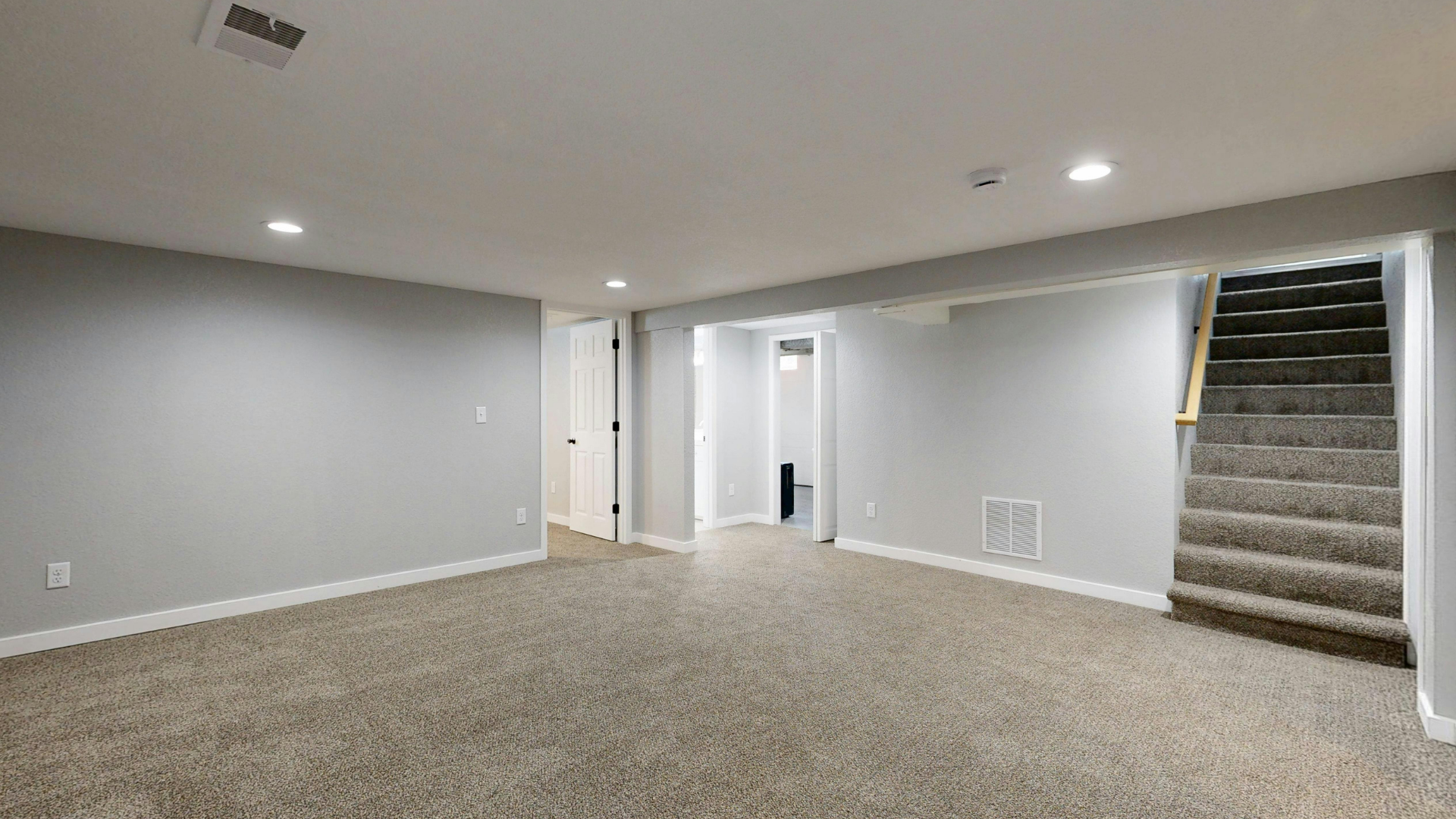 A view of an unfinished bathroom featuring a dark tiled shower floor, white walls, and a glass door on the left.