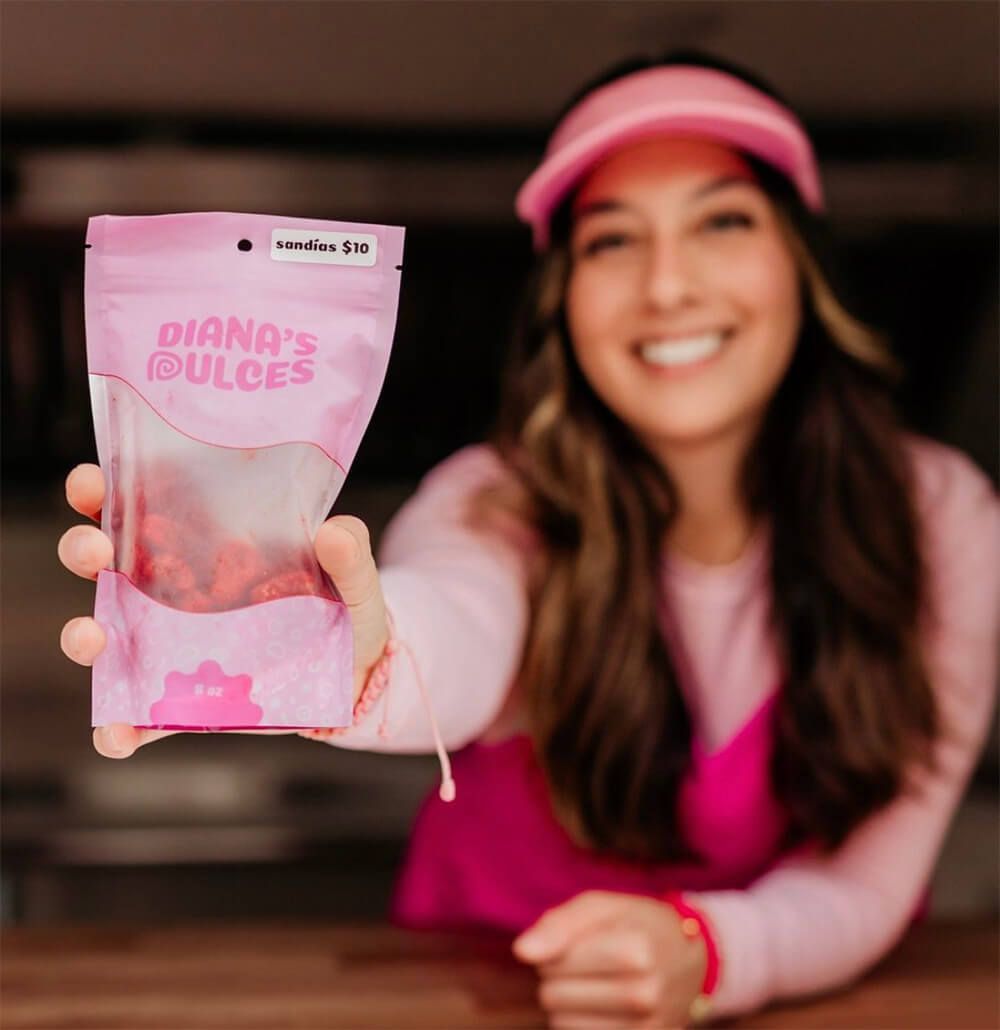 Female-founder holding out her new, custom designed candy pouches.
