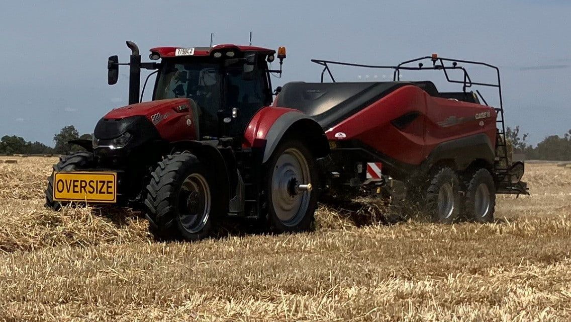 A Red and Black Tractor Is Driving Through a Field — Cheshire Machinery in Murgon, QLD