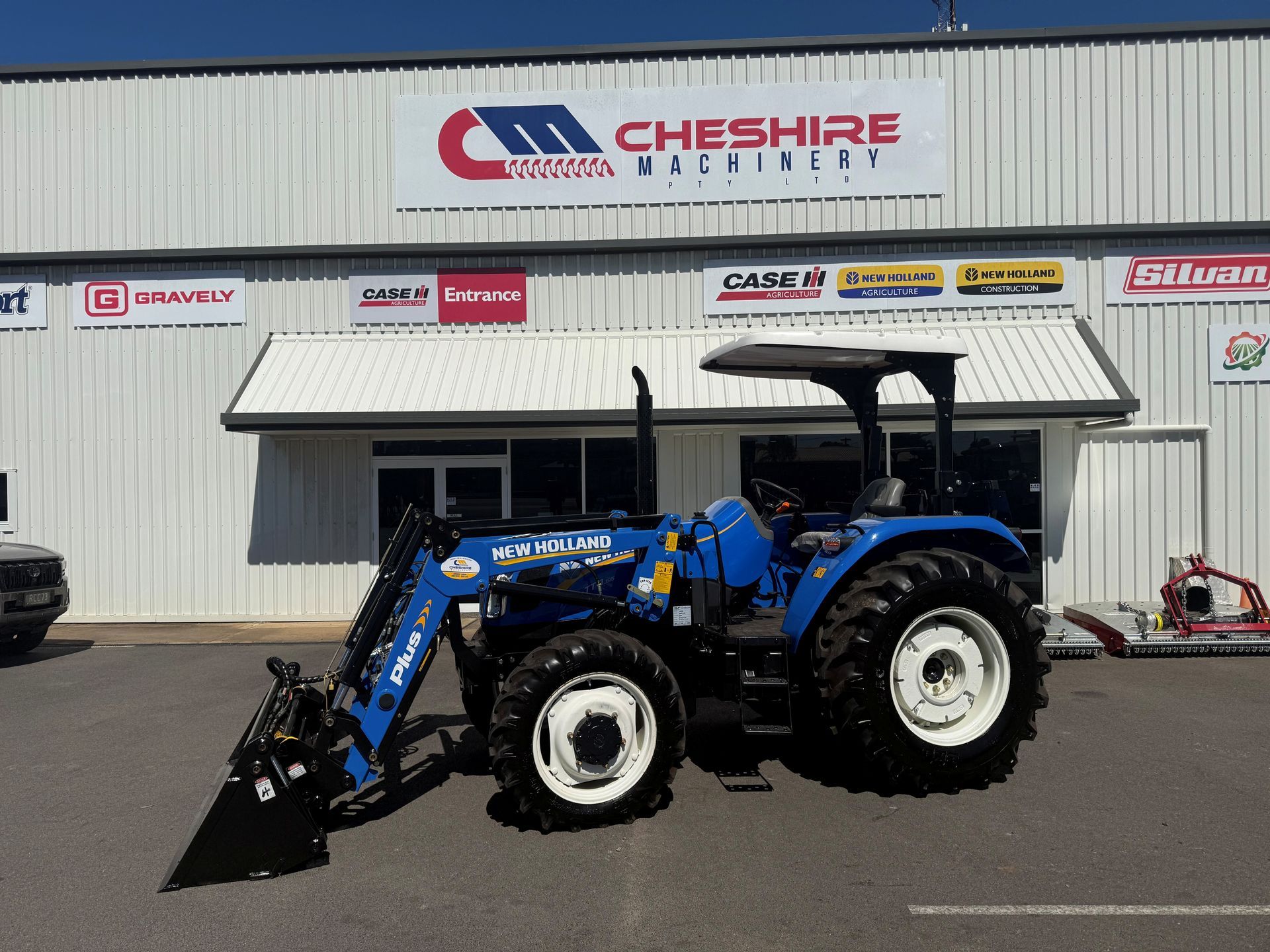A Red Tractor is Parked in Front of a Cheshire Machinery Store — Cheshire Machinery in Murgon, QLD