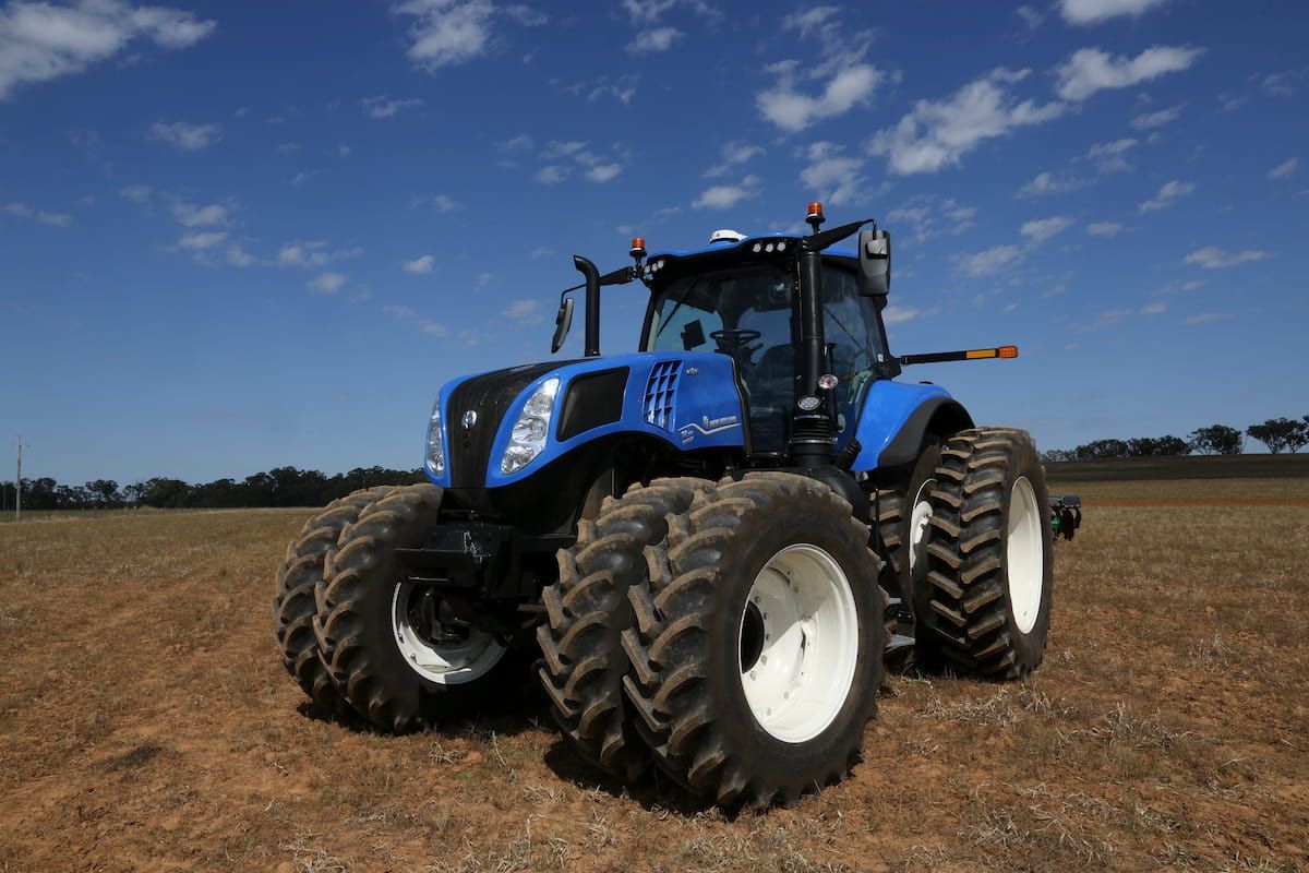 A Blue Tractor Is Parked in The Middle of A Field — Cheshire Machinery in Murgon, QLD