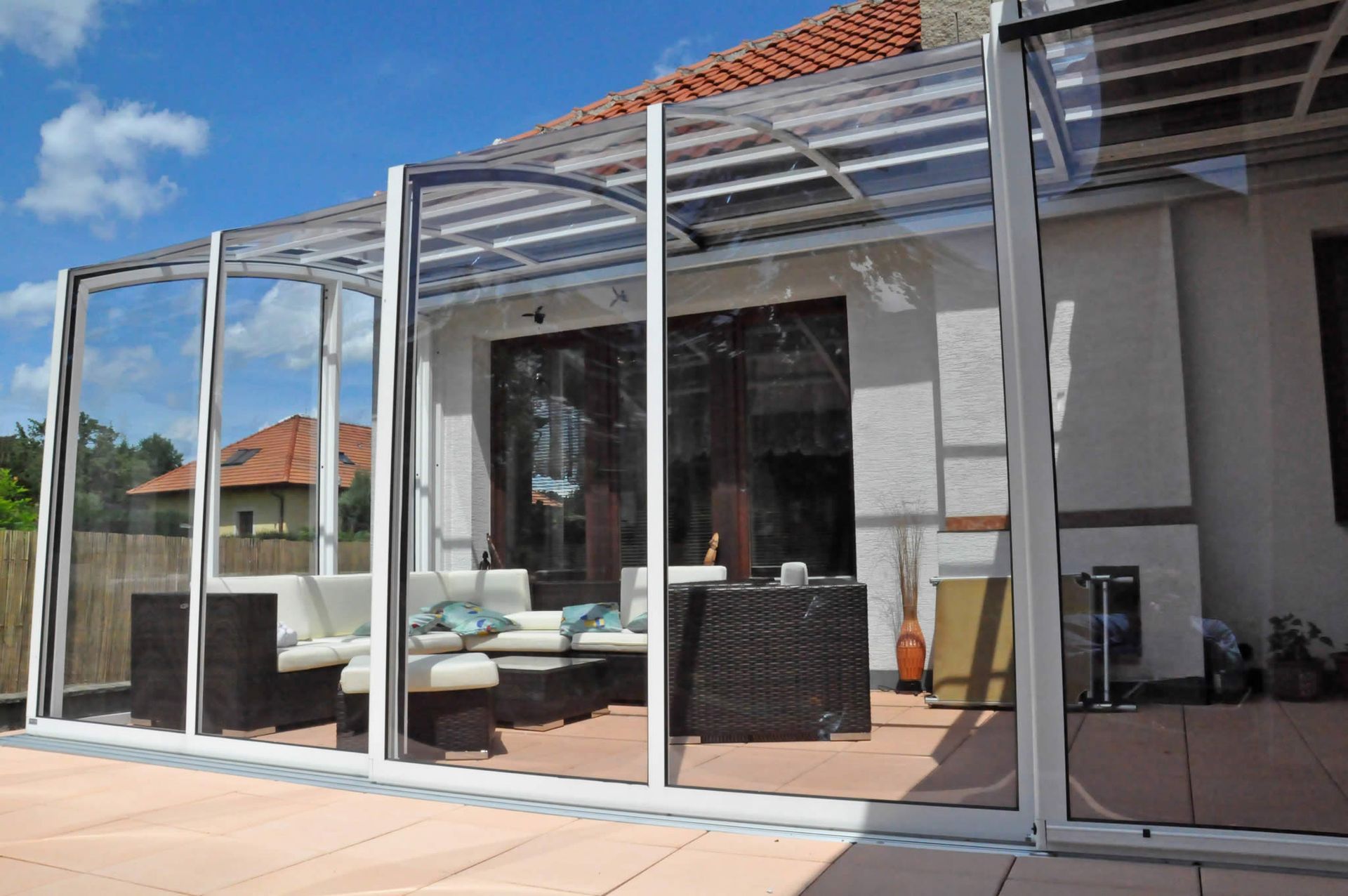 Eine Terrasse mit klarem Dach und Glasschiebetüren