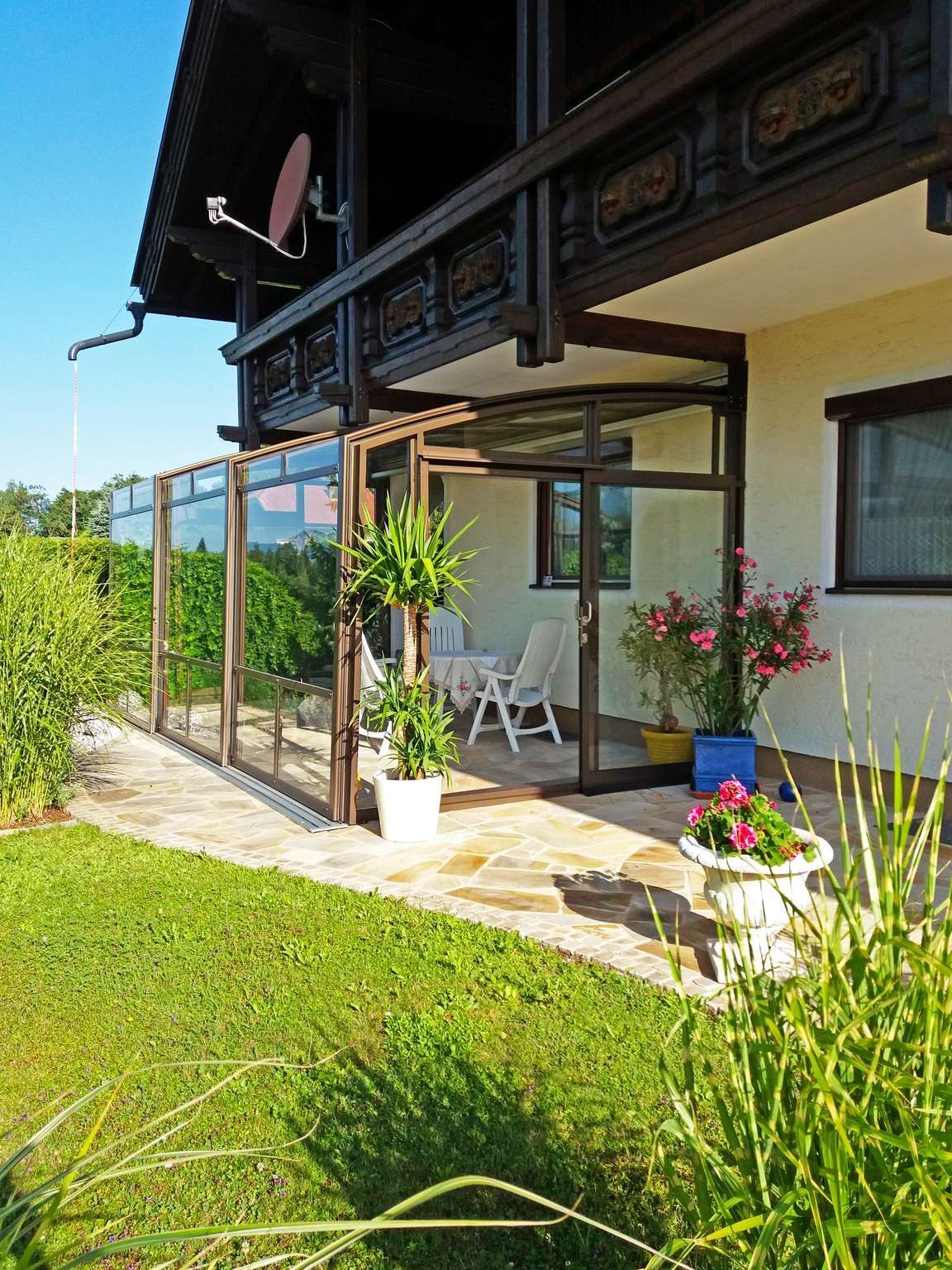 Ein Haus mit einer Terrasse und einer Satellitenschüssel auf dem Dach.