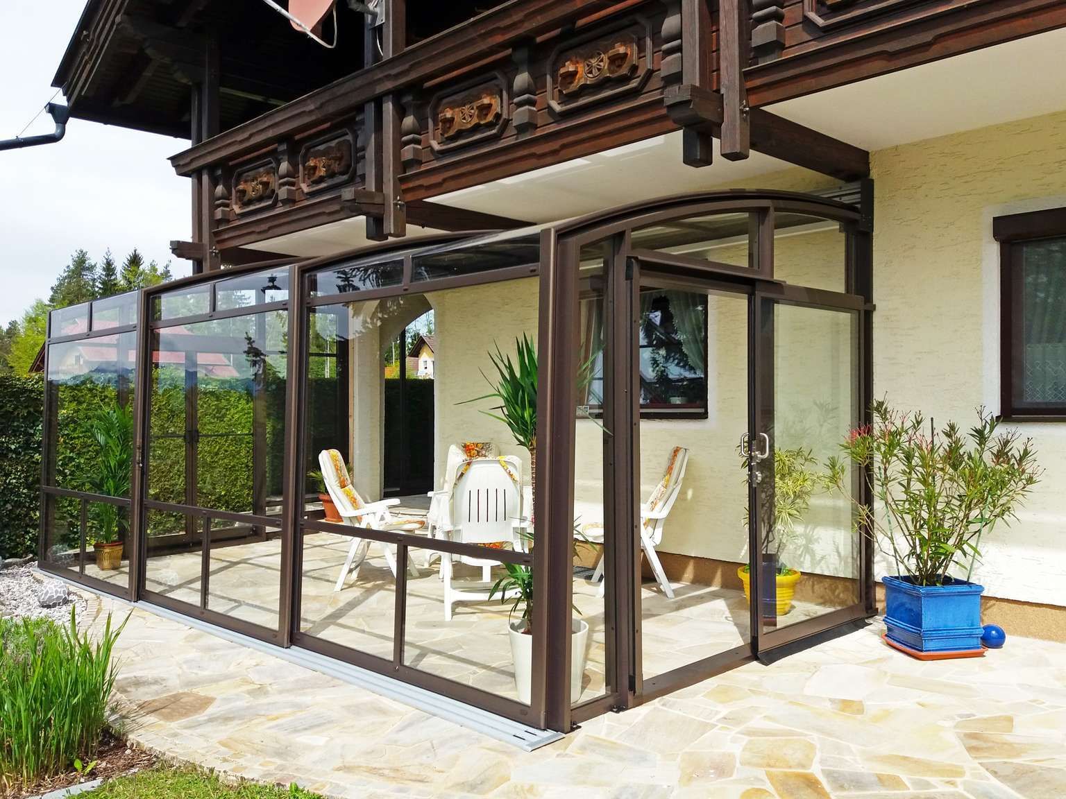 Eine Terrasse mit Stühlen und Tischen vor einem Haus.