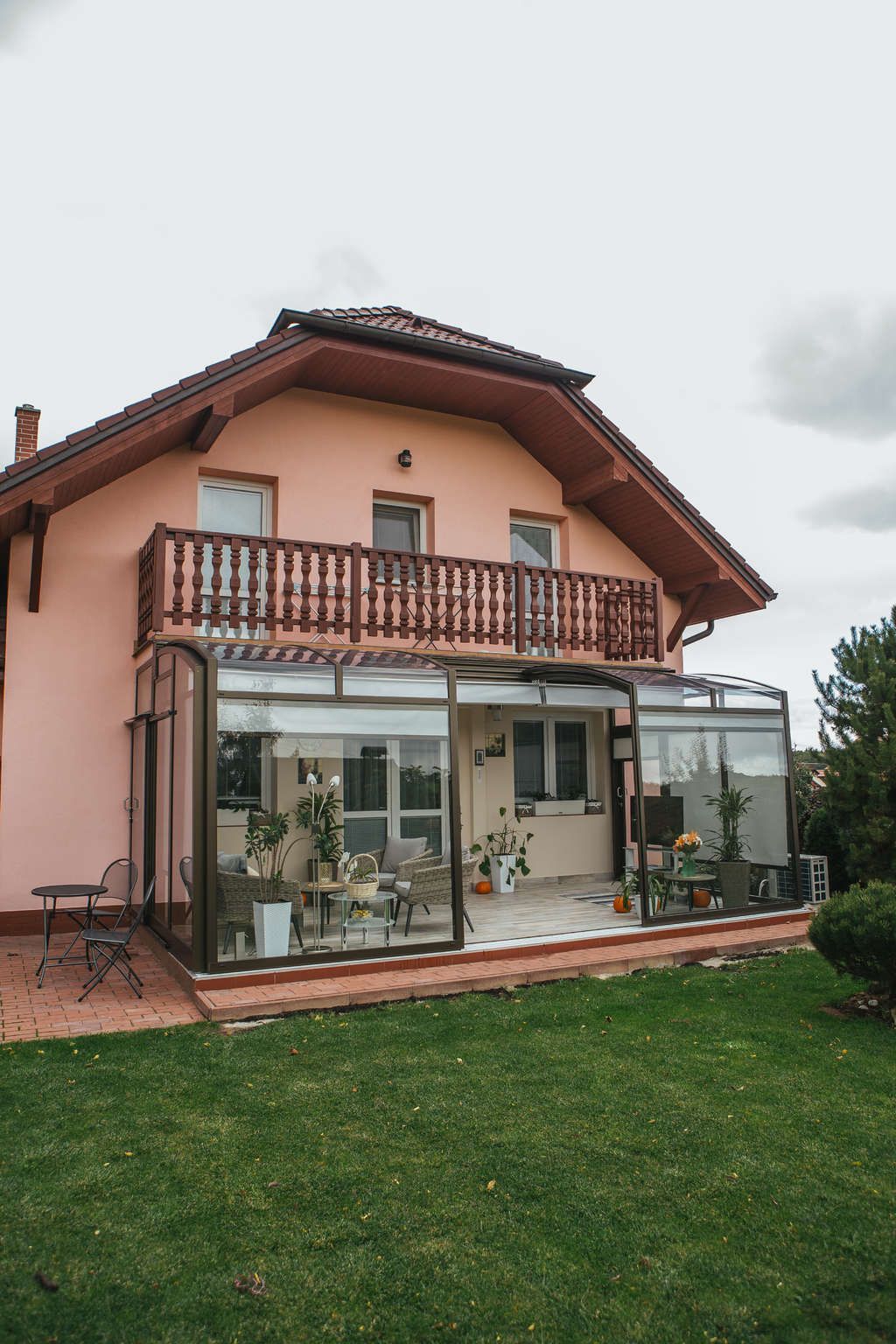 Ein großes Haus mit Balkon und einer grünen Wiese davor.
