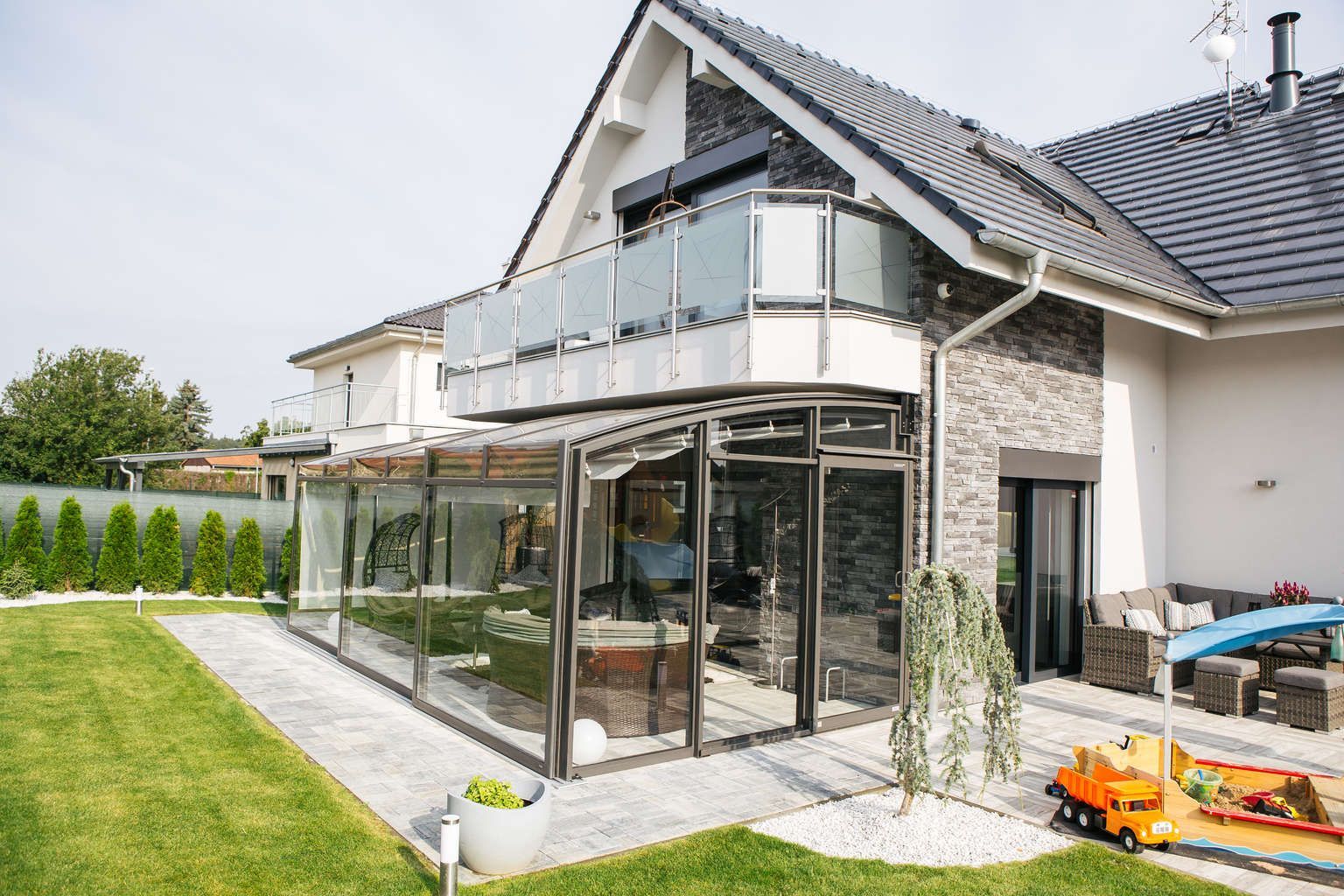 Ein großes Haus mit einer großen Terrasse und einem großen Fenster.
