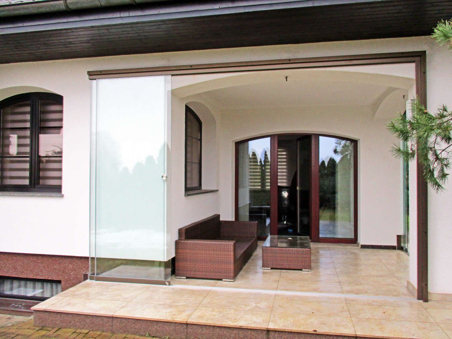 Es gibt eine Terrasse mit einem Sofa und einem Tisch darauf.