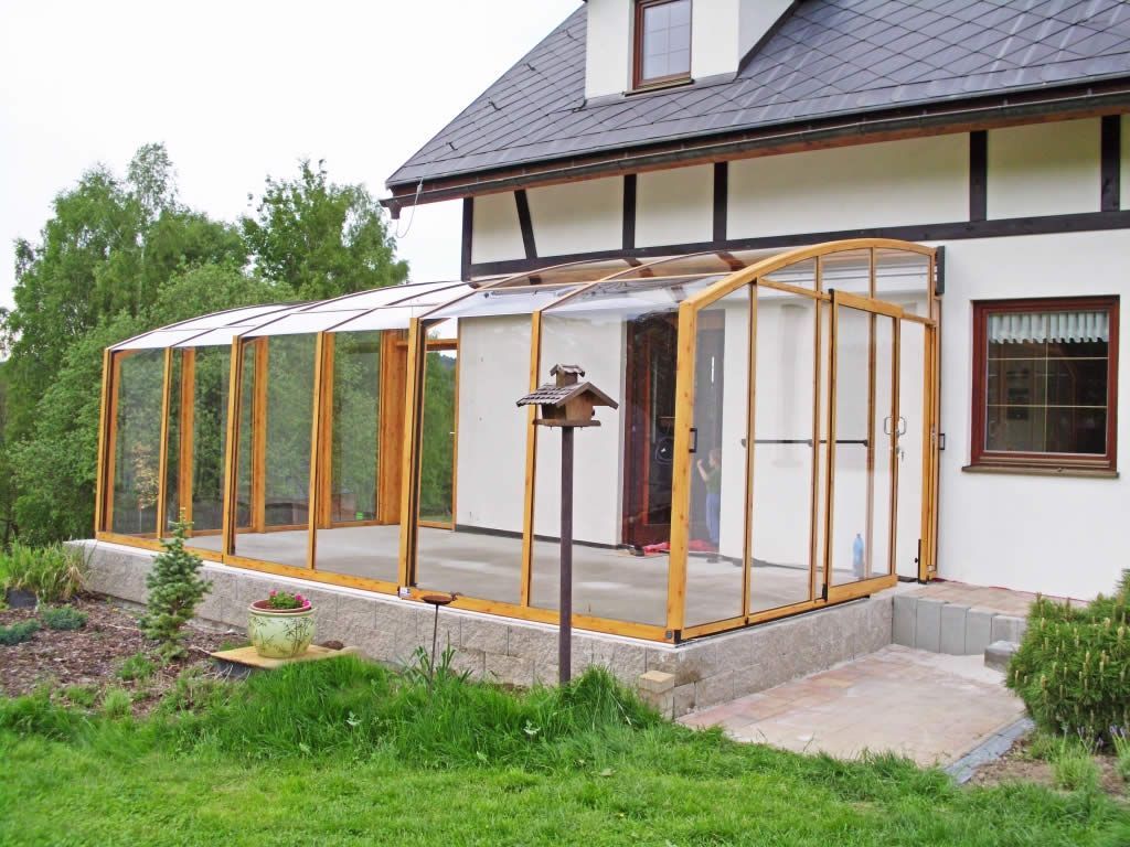 Ein weißes Haus mit einer Holzveranda und einem Vogelhäuschen