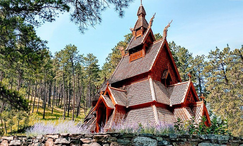 A small wooden church in the middle of a forest.