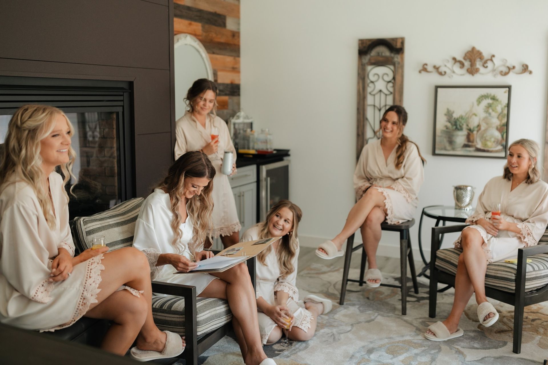 A group of women are sitting around a fireplace in a living room.