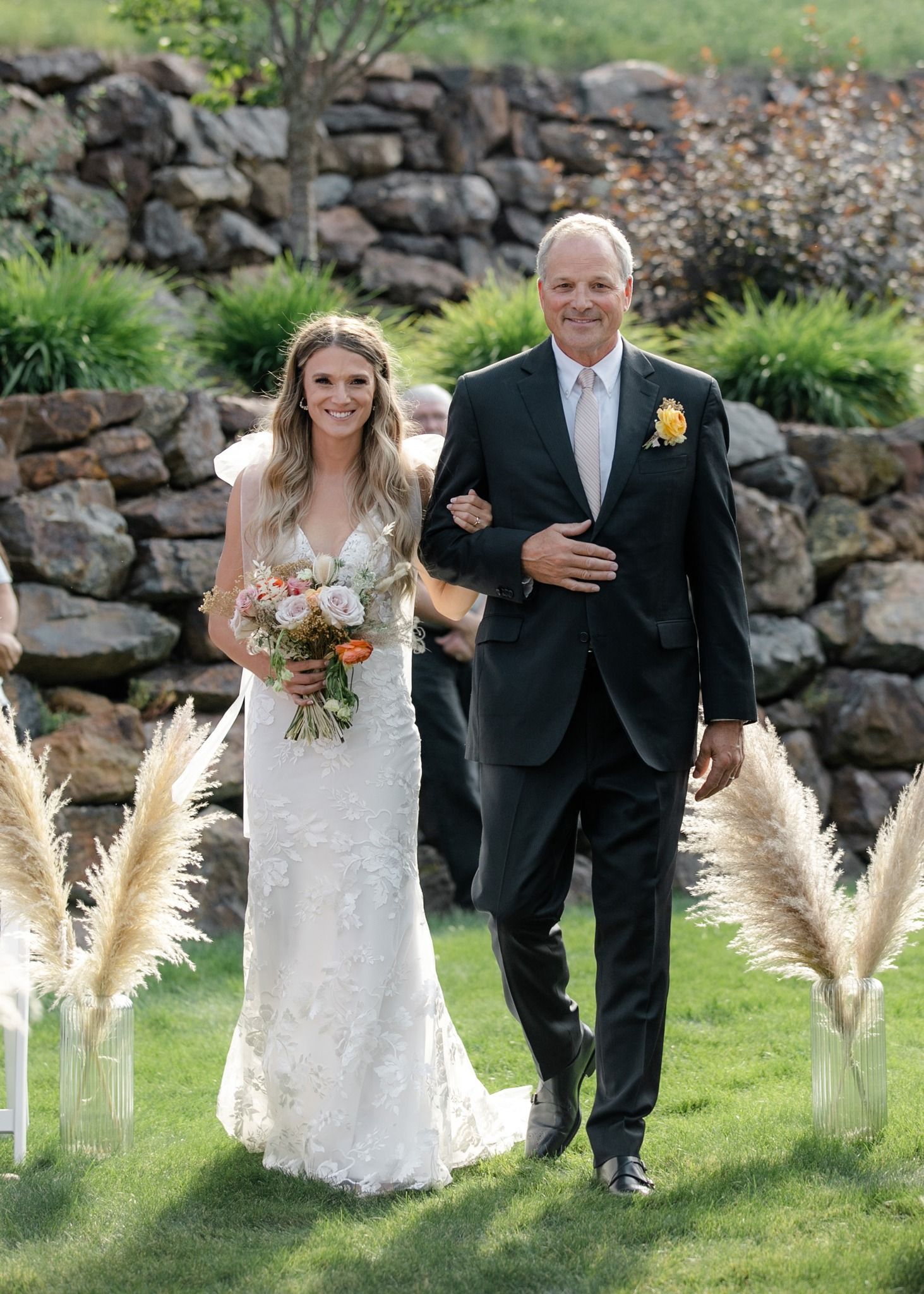 A bride and her father are walking down the aisle at their wedding.
